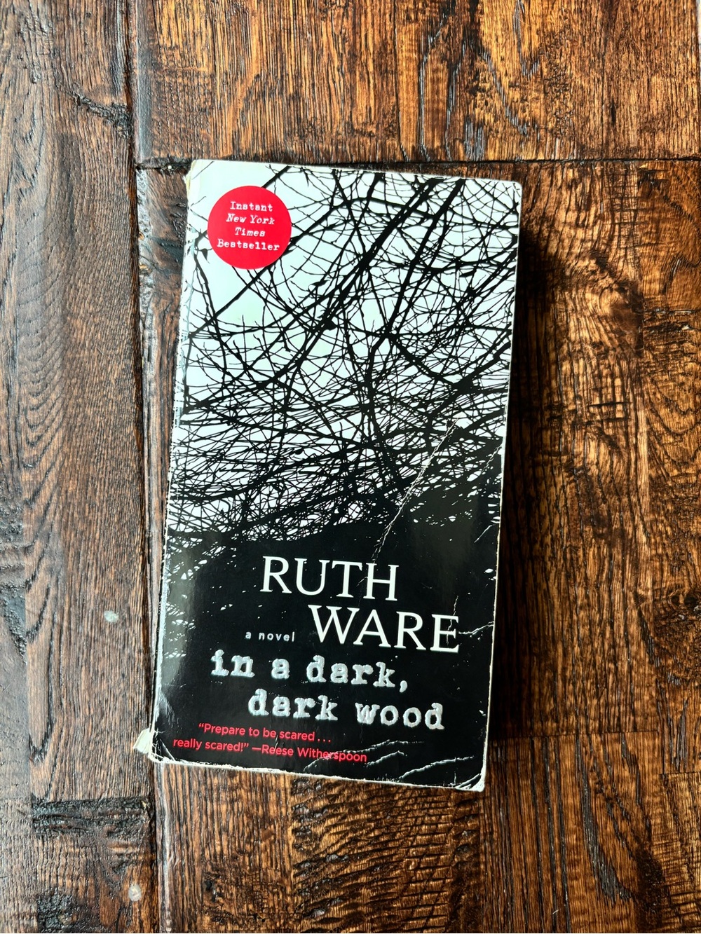 In a dark, dark wood paperback novel book by Ruth Ware